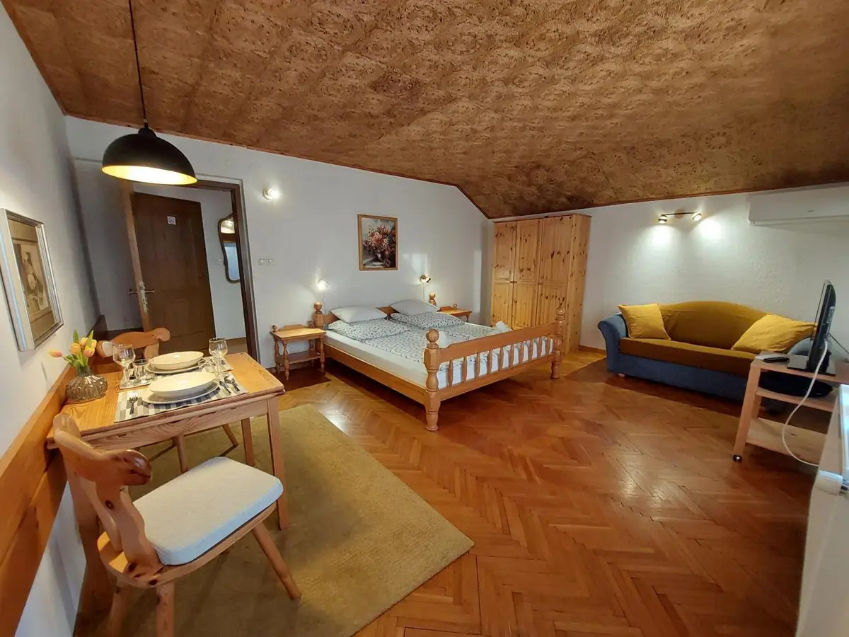 Main room of The Julian Alps - double bed, sofa and dining table in morning light