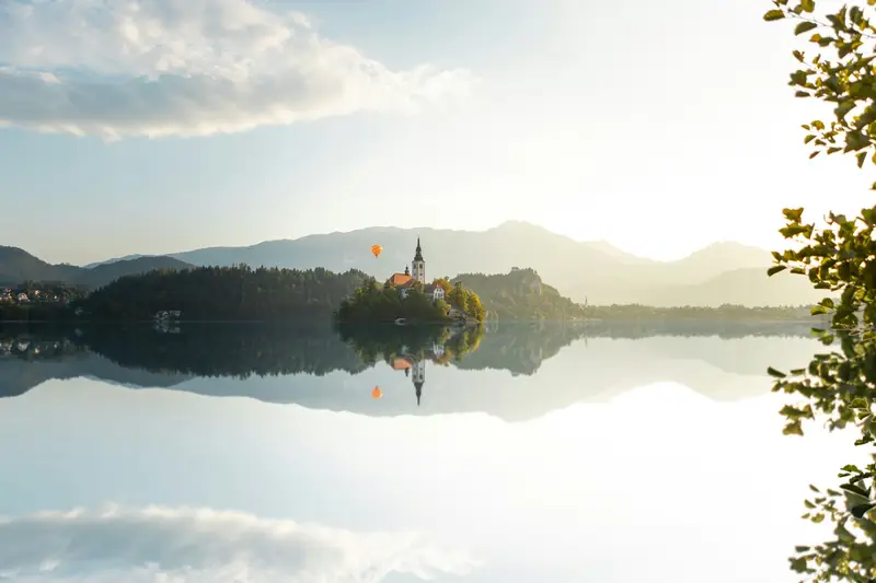Lake Bled at sunrise, the island church mirrored in still water